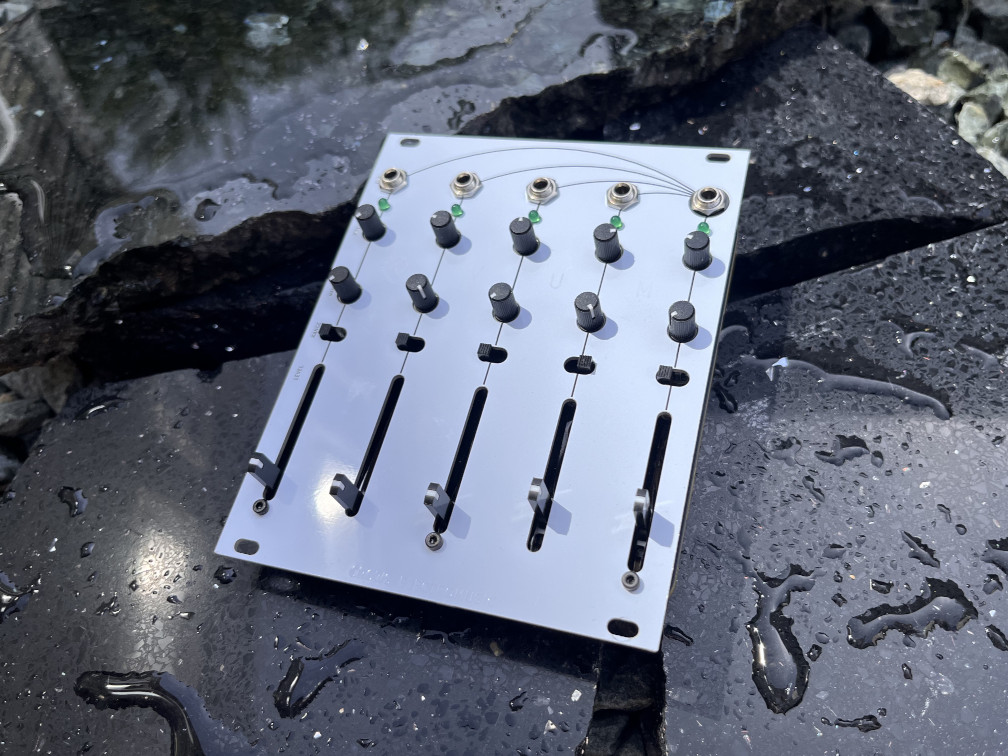 A photo of OVUM for Eurorack, a synthesizer module - a white aluminum electronics panel on shards of black marble